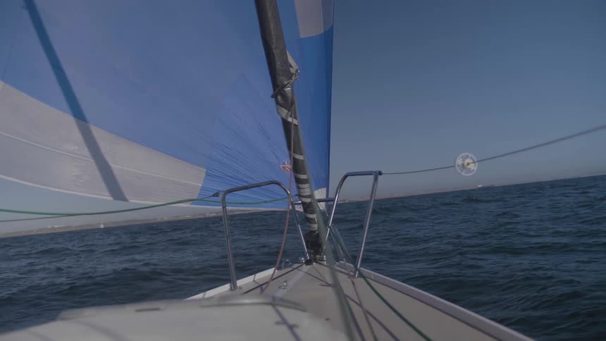 A sailboat rocking on the waves during the day