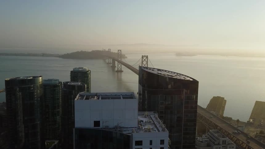 Cars drive on bridge into city at dawn