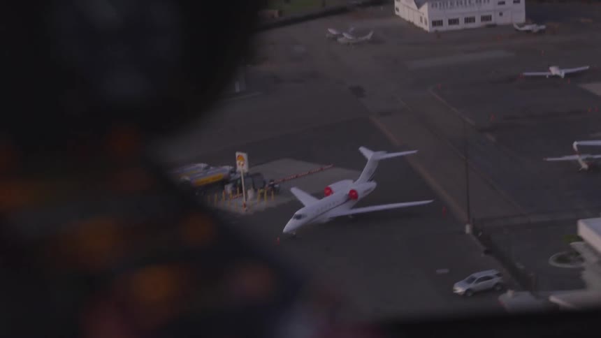 Flying over an airport that has planes sitting on the ground