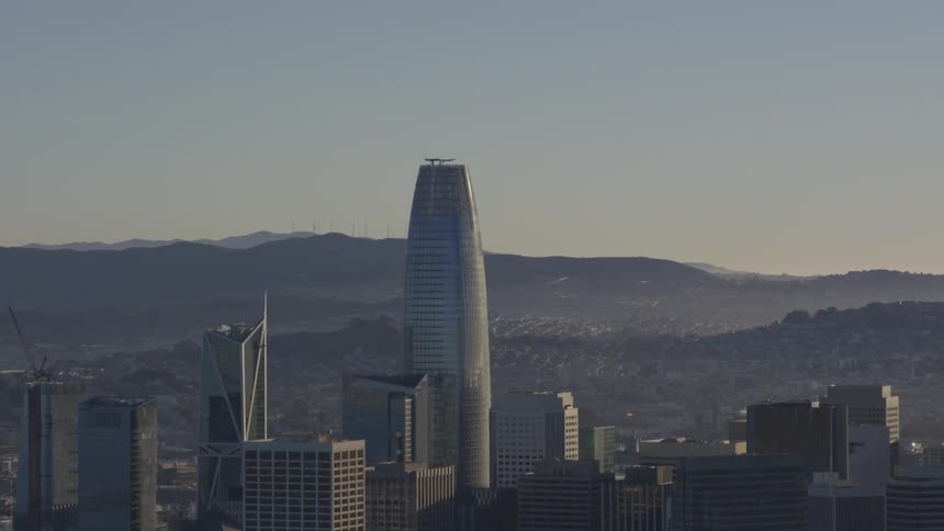 A city skyline of skyscrapers surrounded by hills