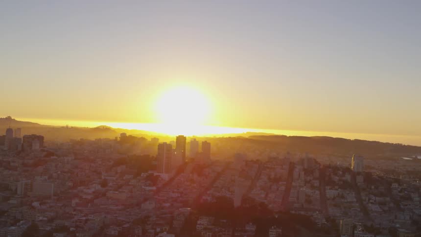 The sun sets over skyscrapers and buildings in a city