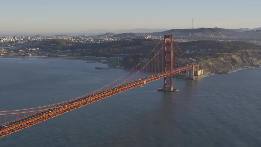 Cars travel in both directions across the golden gate bridge on a sunny day