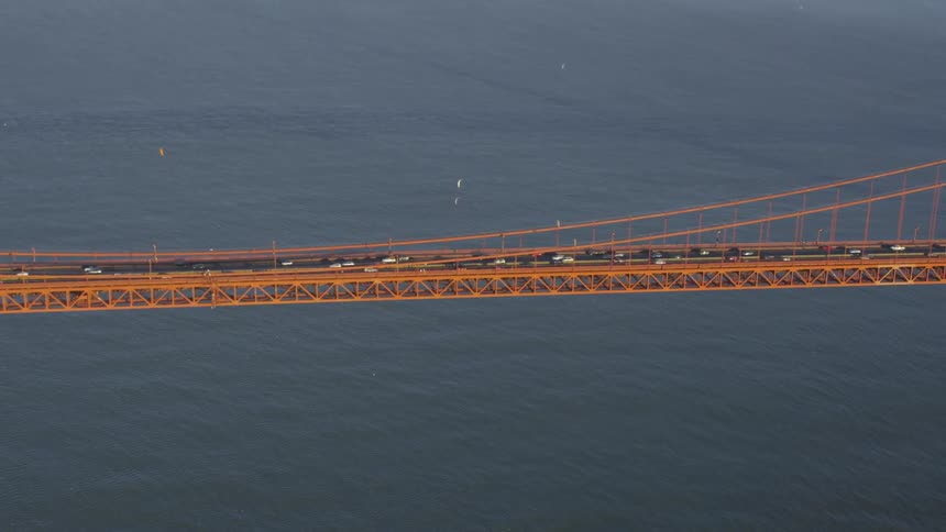 Cars driving across a large bridge over a body of water