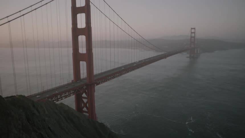 Cars crossing a large bridge at sunset
