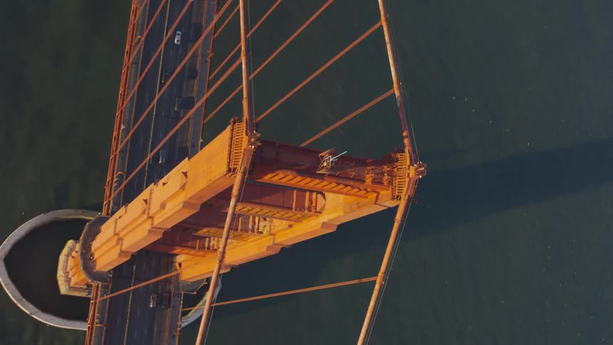 Aerial view of suspension bridge with cars driving over it