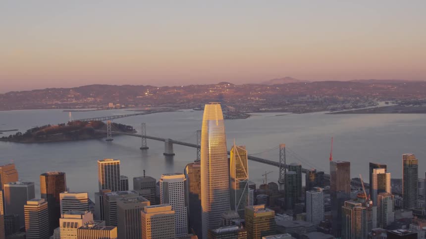 Skyline of the city linked to island by bridge at dusk