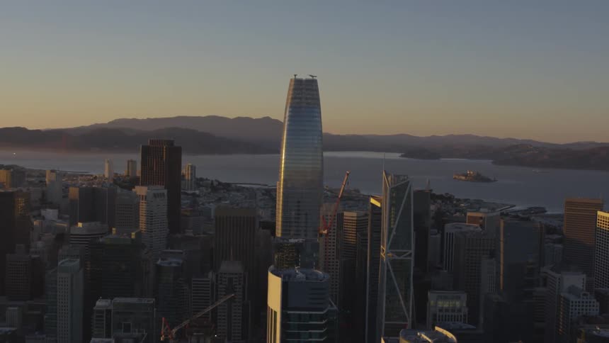 Skyline of the city next to the sea while sun goes down