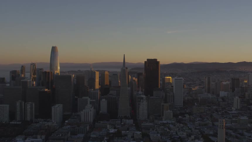 The sun is setting in the horizon of a city