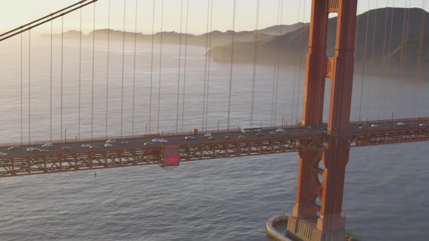 Flying over a bridge that has a lot of cars driving on it