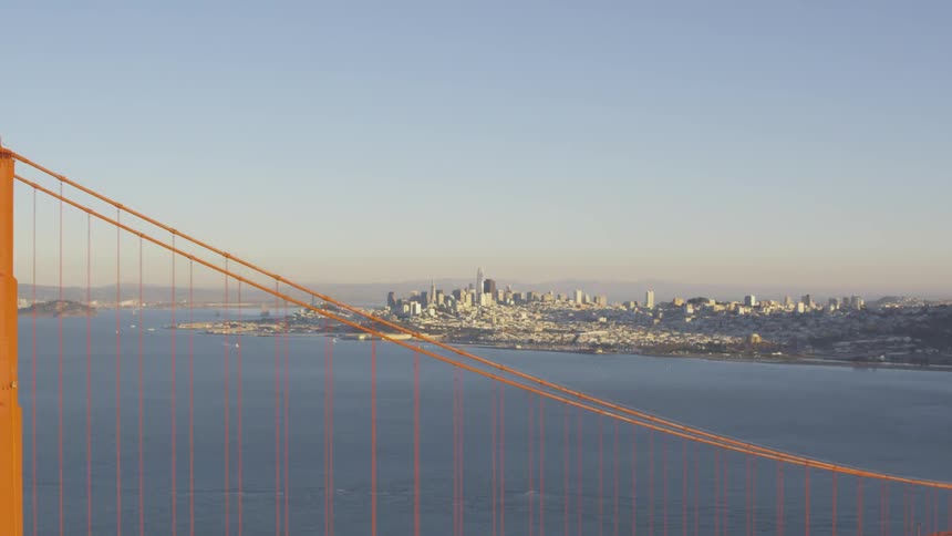 The city of san francisco is seen beyond the towers of the golden gate bridge on a clear and sunny day