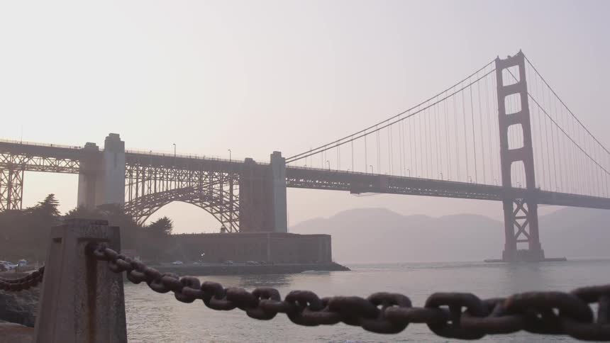 On a dreary and foggy day the golden gate bridge stands solemnly as it spans over the cold water