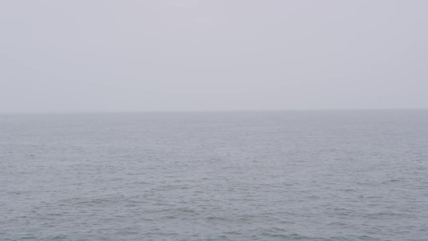 Sea flows downstream on a foggy day