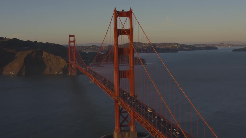 Cars crossing the golden gate bridge at sunset