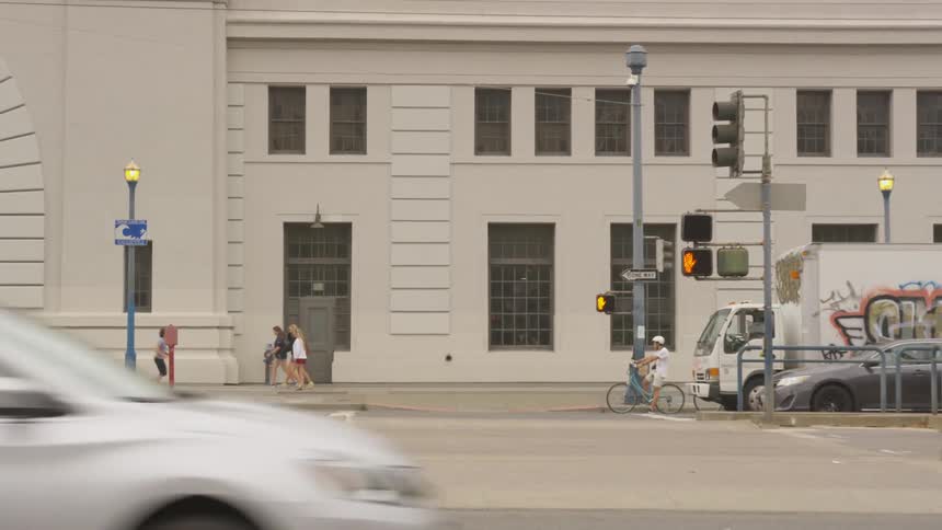 People walking and running down a sidewalk in a city