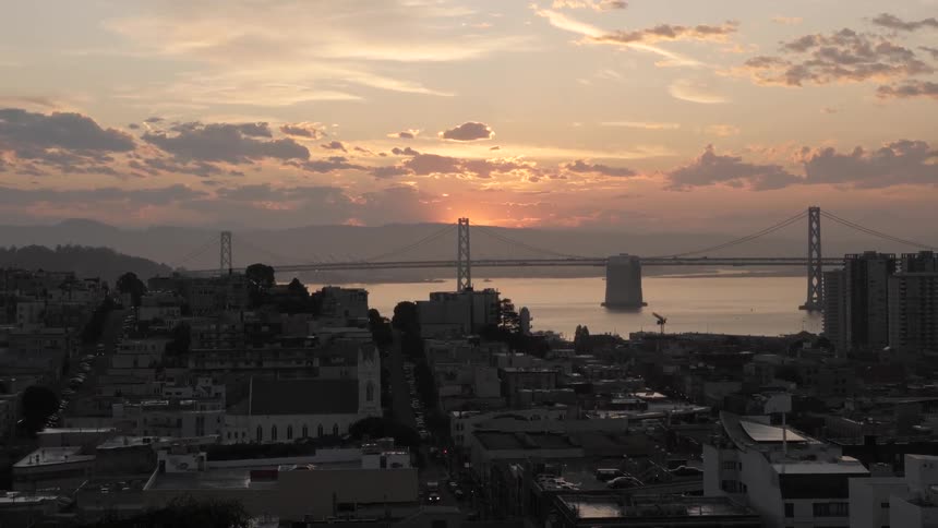 View at dusk of a suspension bridge beyond the city
