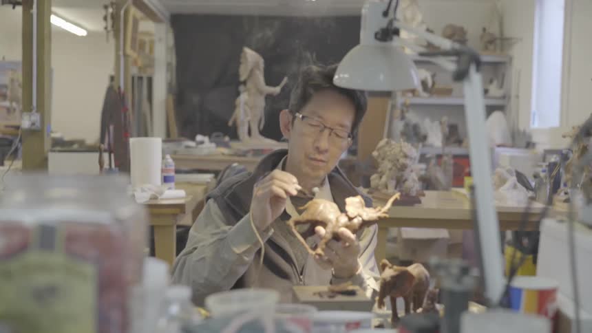 A man is making pottery indoors