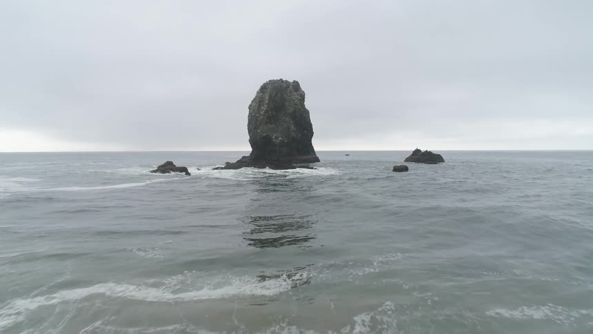 Waves are moving in the ocean by a rock