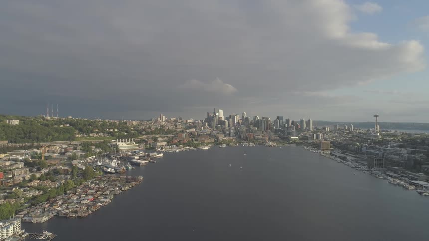 A float plane flies over a city surrounding a body of water