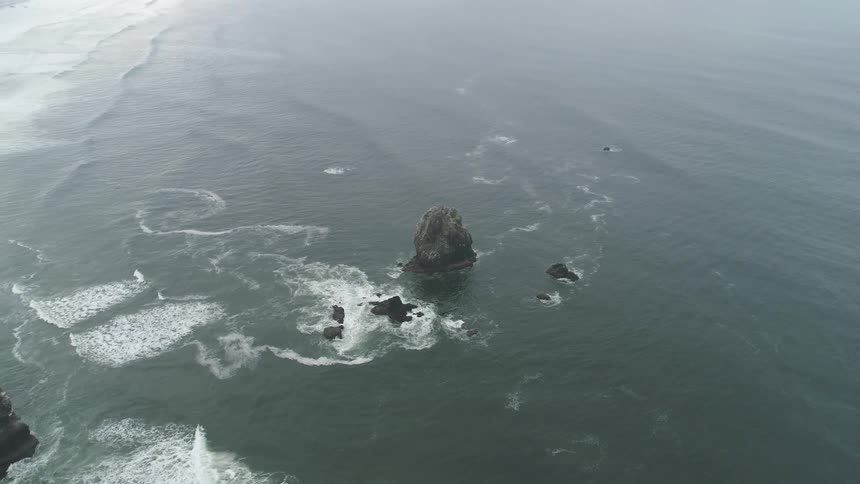 Waves breaking against rock in the middle of the ocean