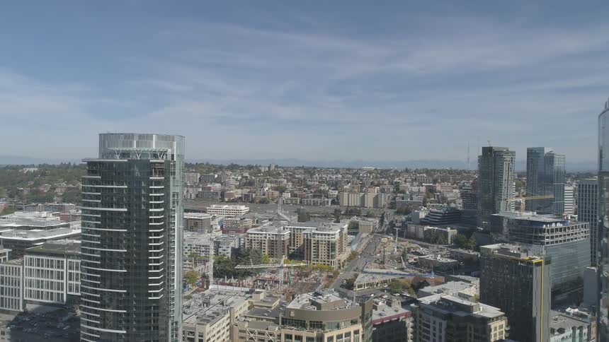 Windows of the city skyscrapers reflect the buildings and sky on a sunny day