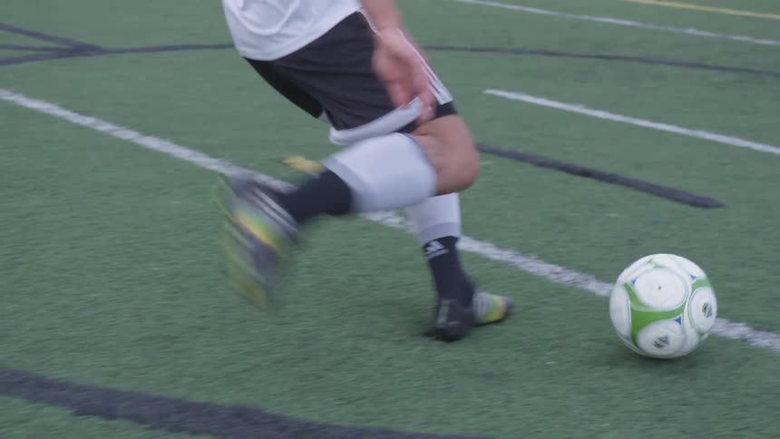 A soccer player takes a shot with his right foot