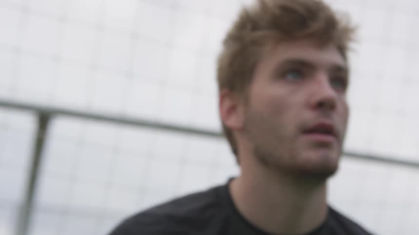 A blonde male bounces from side to side in front of a net