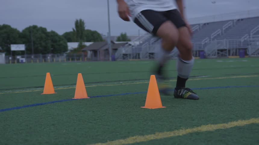 Man practices and kicks soccer ball on field