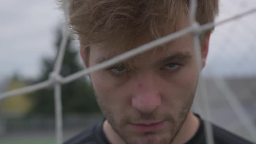Man looks through soccer goal net