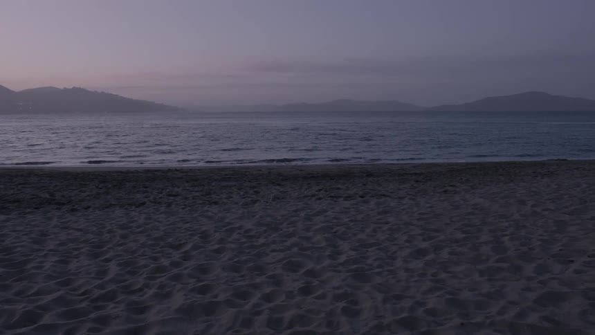 Ocean waves wash ashore a sandy beach