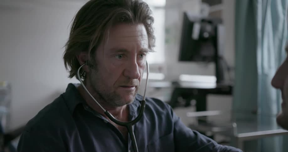 Doctor wears a stethoscope while talking to a patient