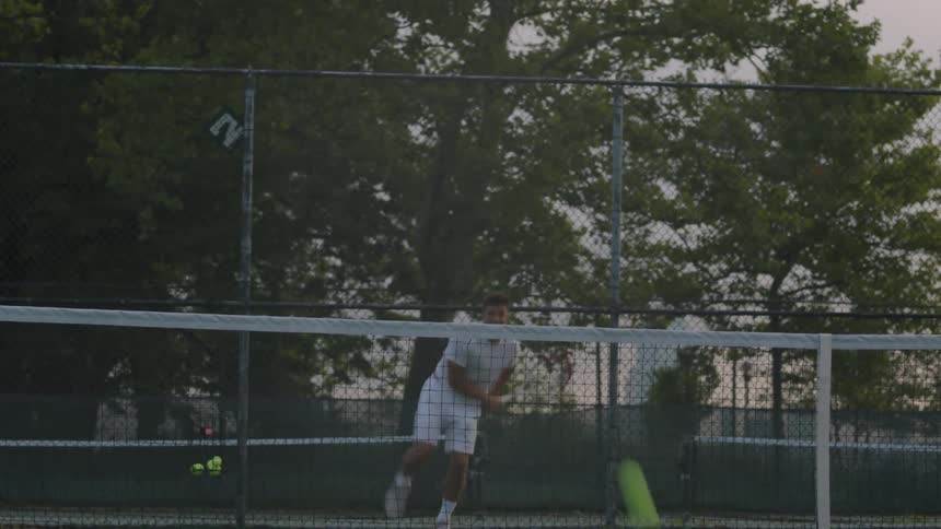 A man practices hitting tennis balls