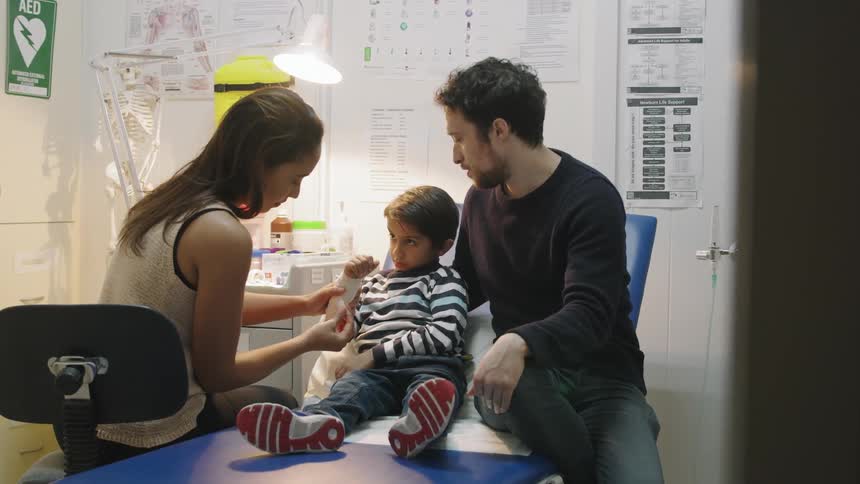 A female doctor attends to a young boy