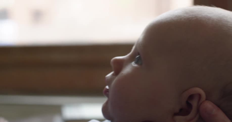 Close up of a baby's face and waving hand