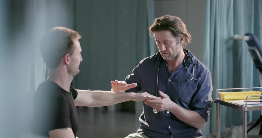 Doctor examines a man's arm