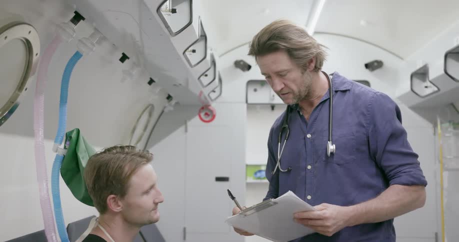 A doctor talks to a man and takes notes