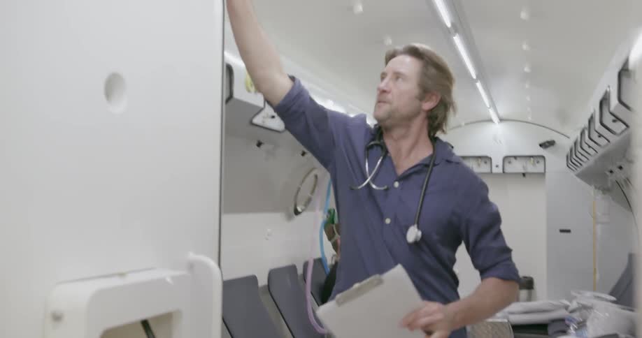 A doctor leaves a man with an oxygen mask in a room