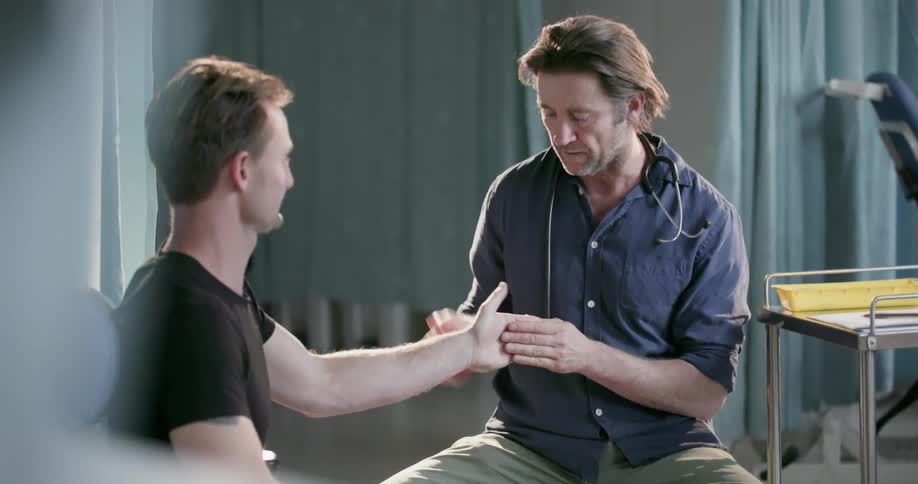 A doctor examines a patient's hand