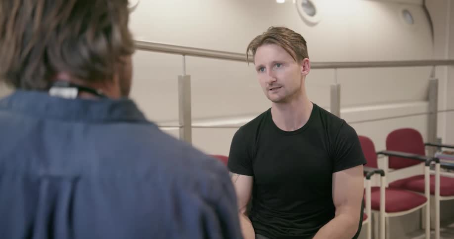 A man answers a doctor's questions as the doctor examines his arm