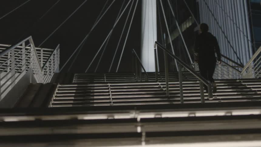 A woman climbing up steps at night