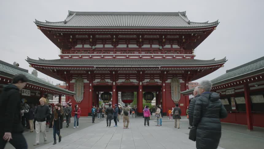 Pedestrians walk in front of an asian building