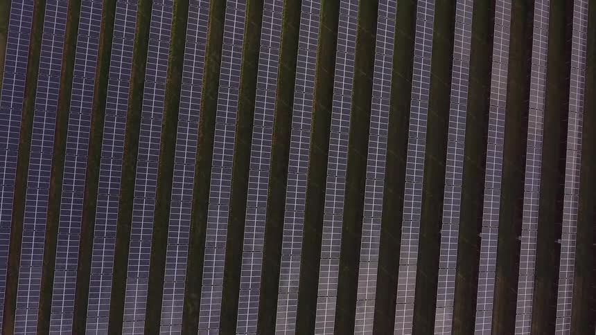 Rows upon rows of solar panels are seen lined up outdoors