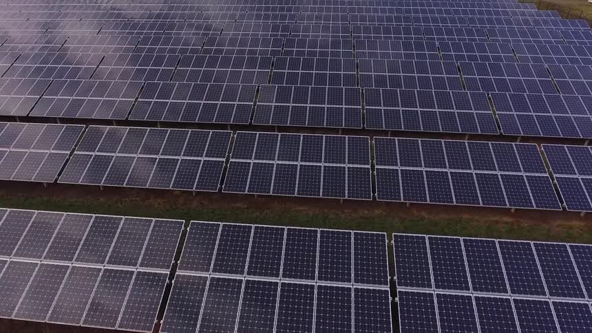 Rows of solar panels on grassy field