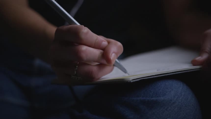 A person is writing on a paper