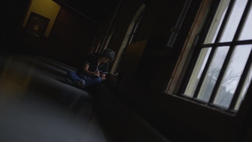 A person is sitting alone in a dark room