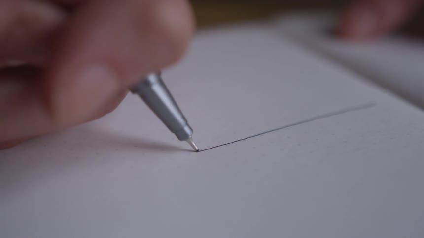 Person draws a line on a sheet of paper
