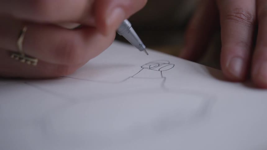 Person draws a figure on a sheet of paper