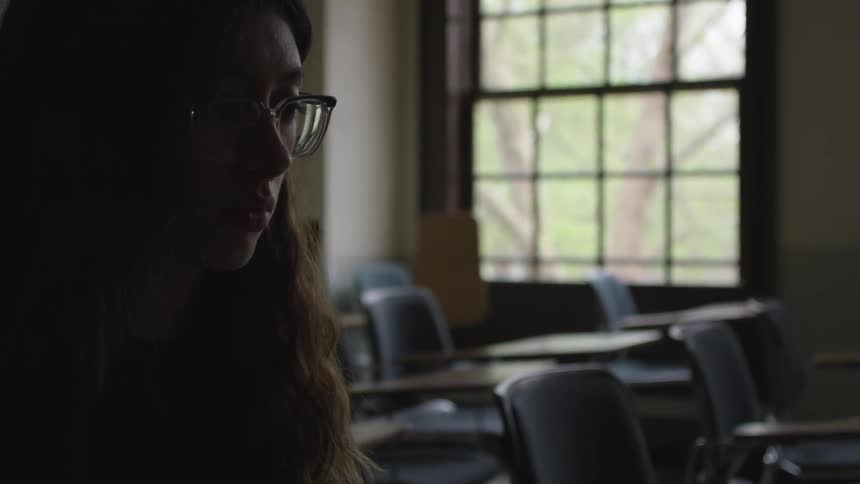 Girl sits at a desk looking forward