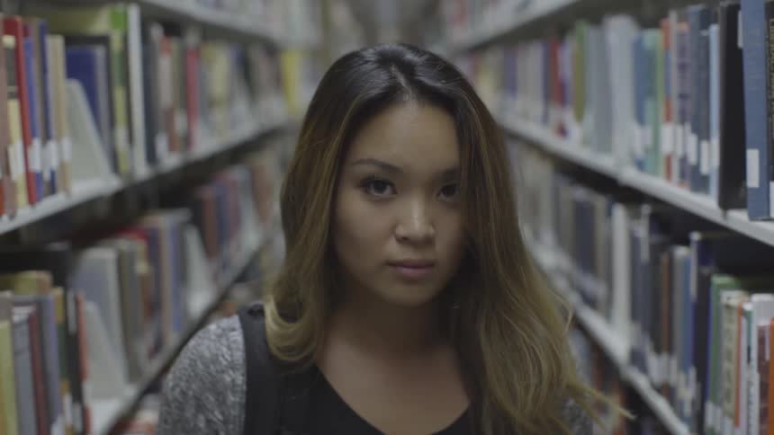 Woman on a library looking at the camera