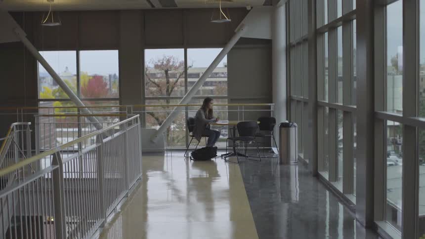 A girl studying at a table in a large building