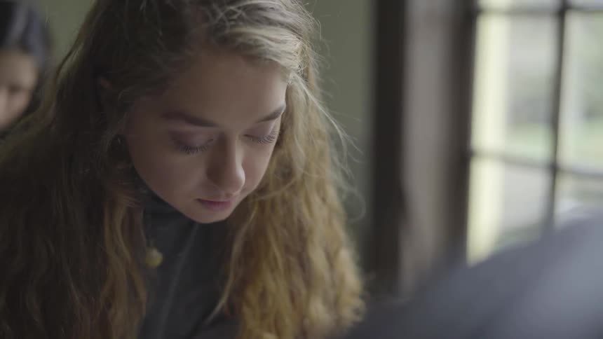 Girl looks down at something out of frame